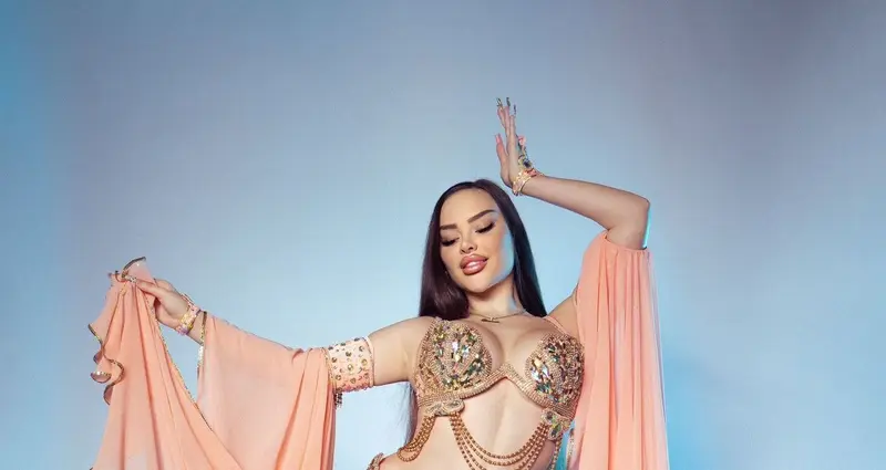 Belly dancer BI dancing in a peach costume with long sleeves