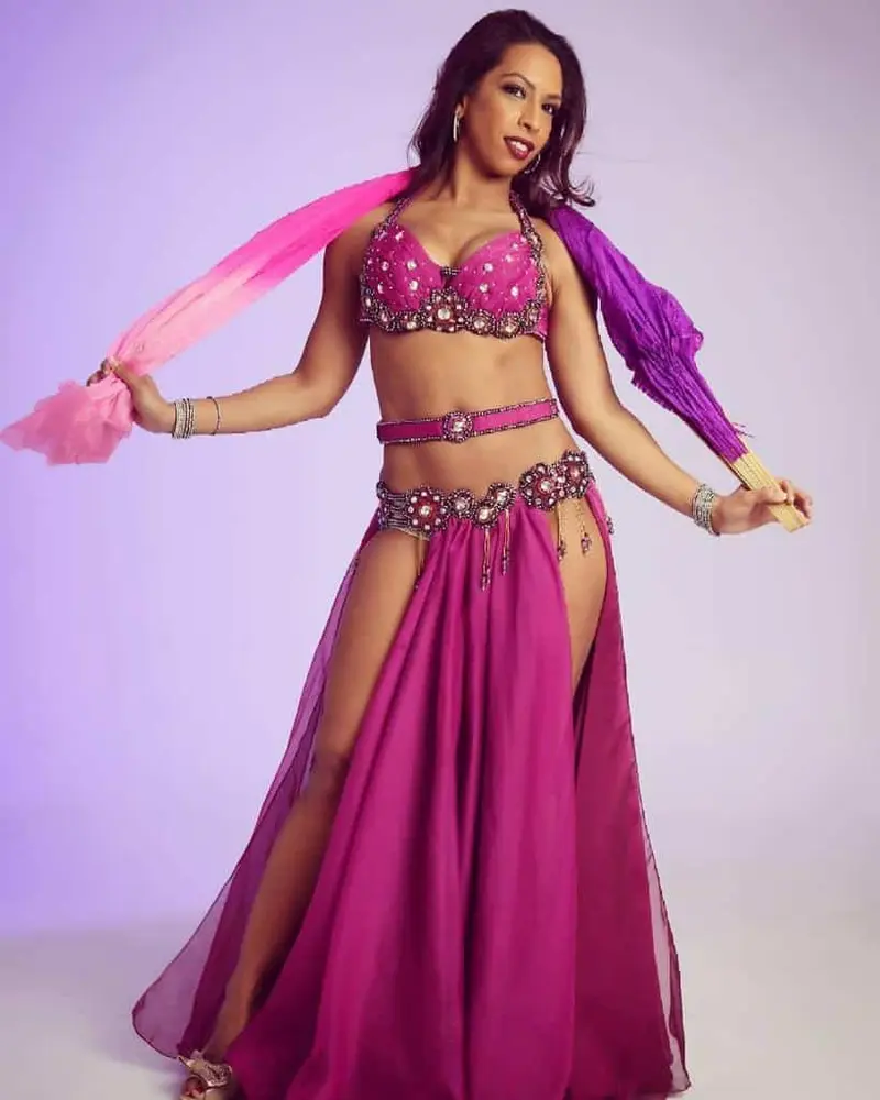 Belly dancer D in a magenta costume with a pink veil