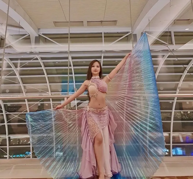 Belly dancer posing with one iridescent wing raised