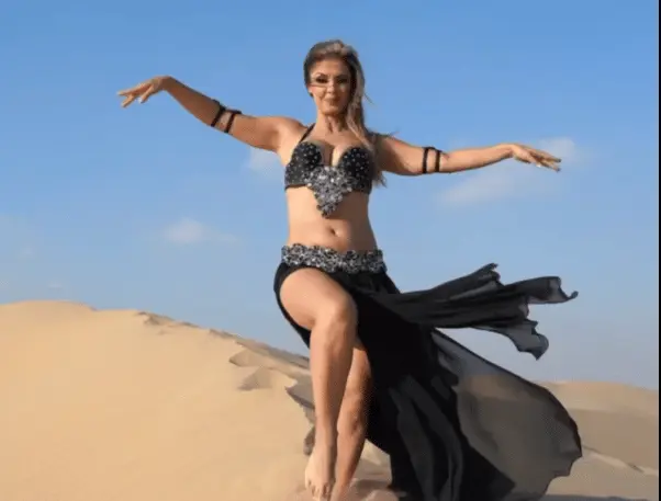 Belly dancer R dancing on a sand dune