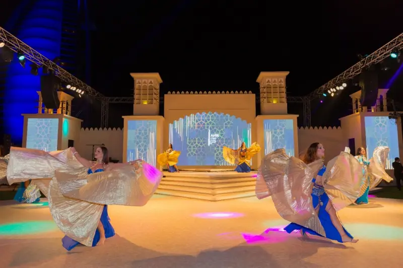 Belly dancers with silver wings on a large event stage