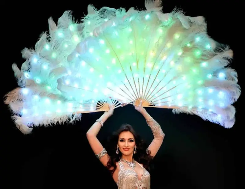 Eve, belly dancer, with a large glowing feather fan