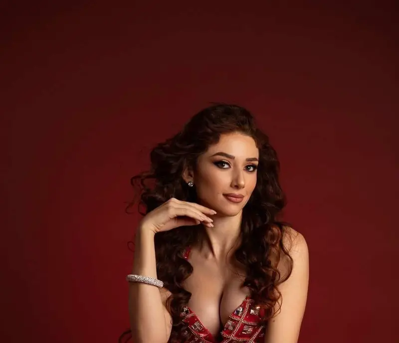 Marika, belly dancer, seated in a red costume