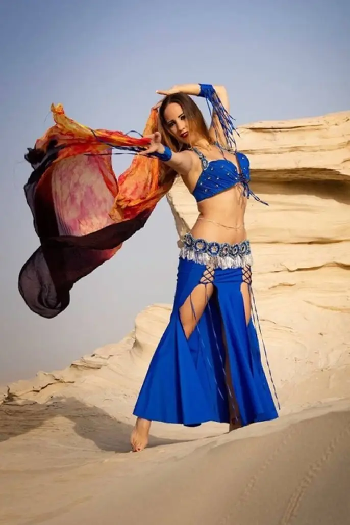 Shaima, belly dancer, with a flowing veil on desert rocks