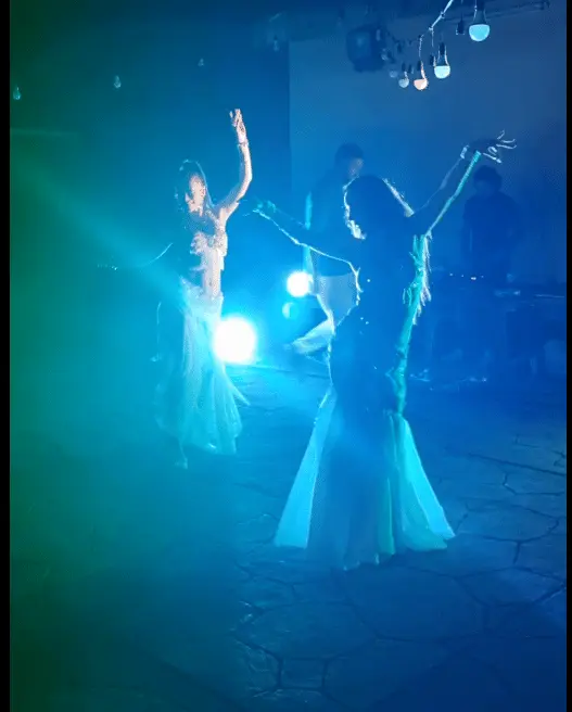 Zulia, belly dancer, performing on stage under blue lights