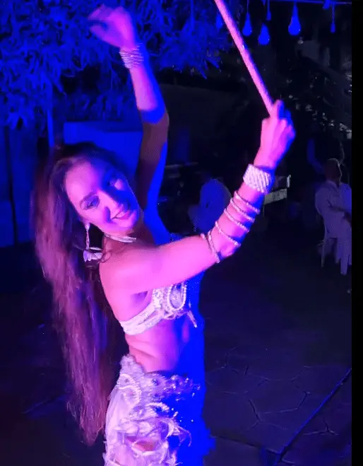 Zulia, belly dancer, performing with a cane under blue lights