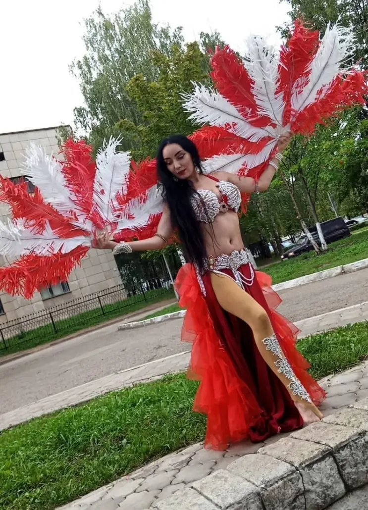 Zulia, belly dancer, with red and white feather fans